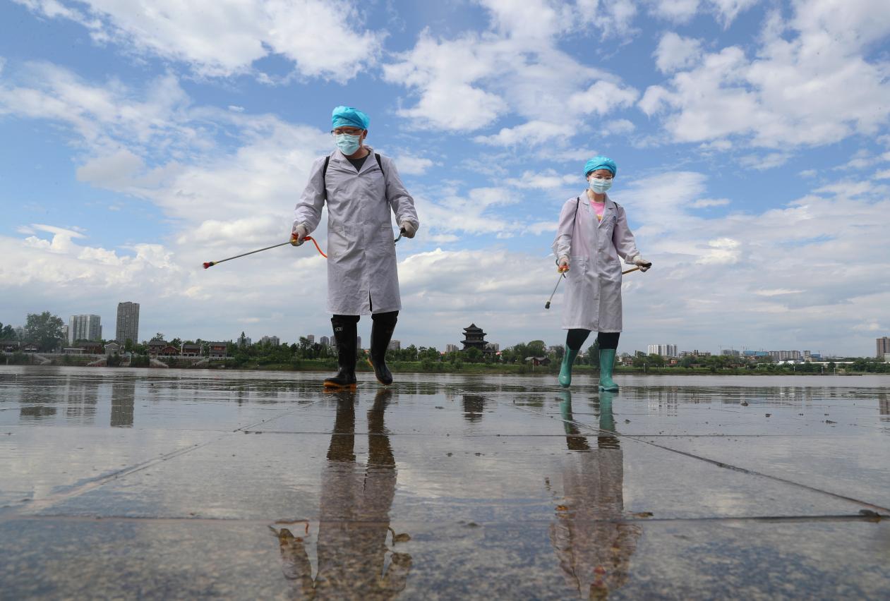 2021年5月26日。在湖南省衡阳市雁峰区千吨级码头沿江风光带，beat365亚洲版官网公共卫生学院的党员志愿者在给清除淤泥后的地方举行消毒。  (2)